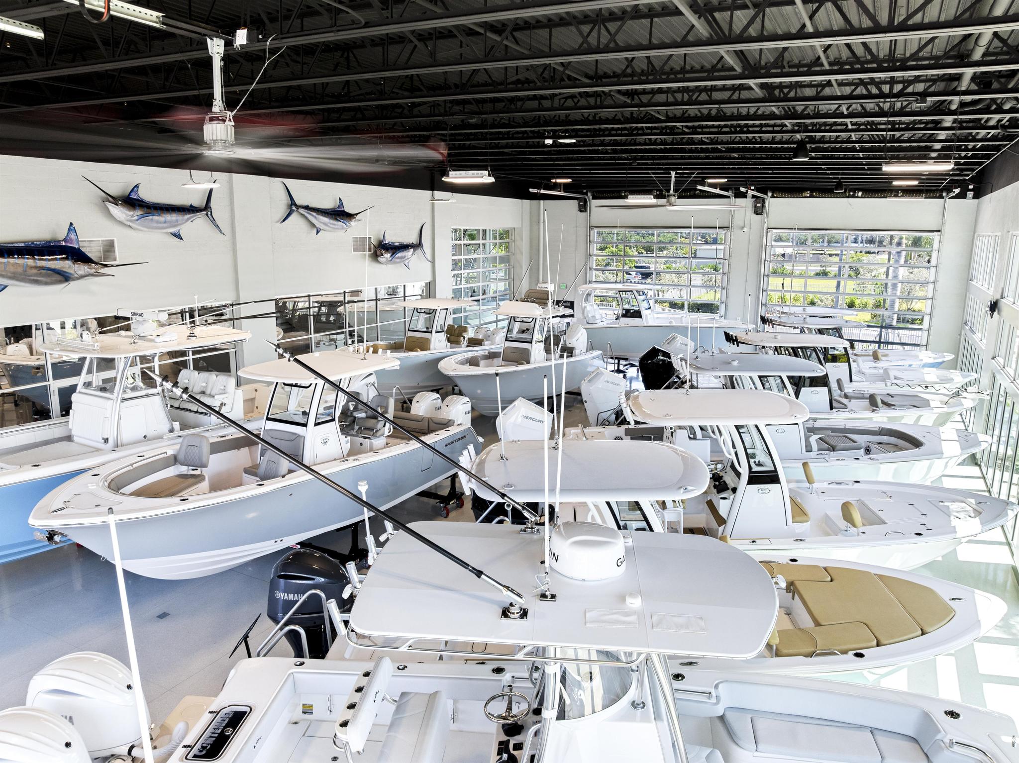 Center consoles lined up beneath the marlin mounts on the showroom wall