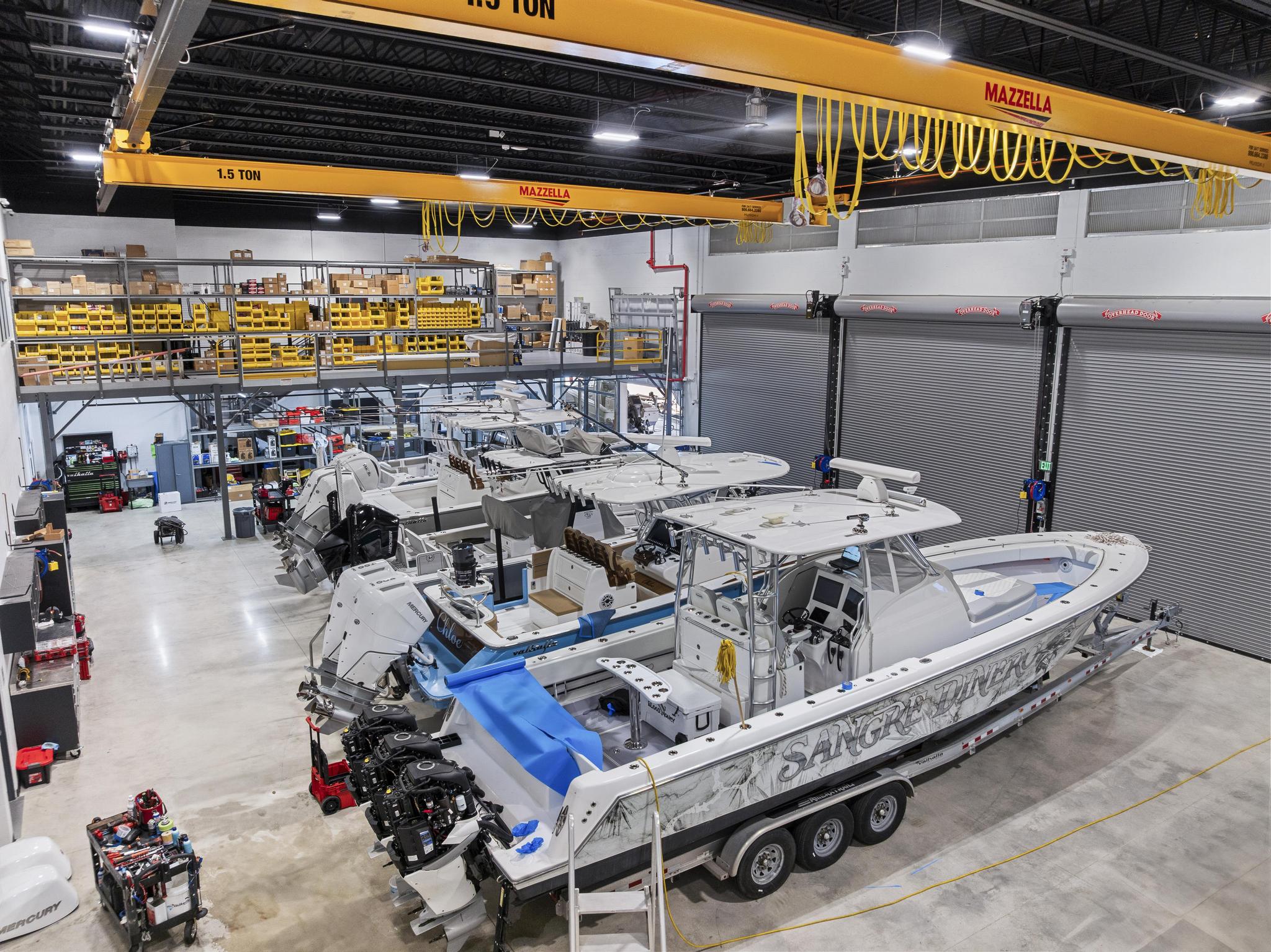 Service warehouse floor with a row of boats under the gantry crane
