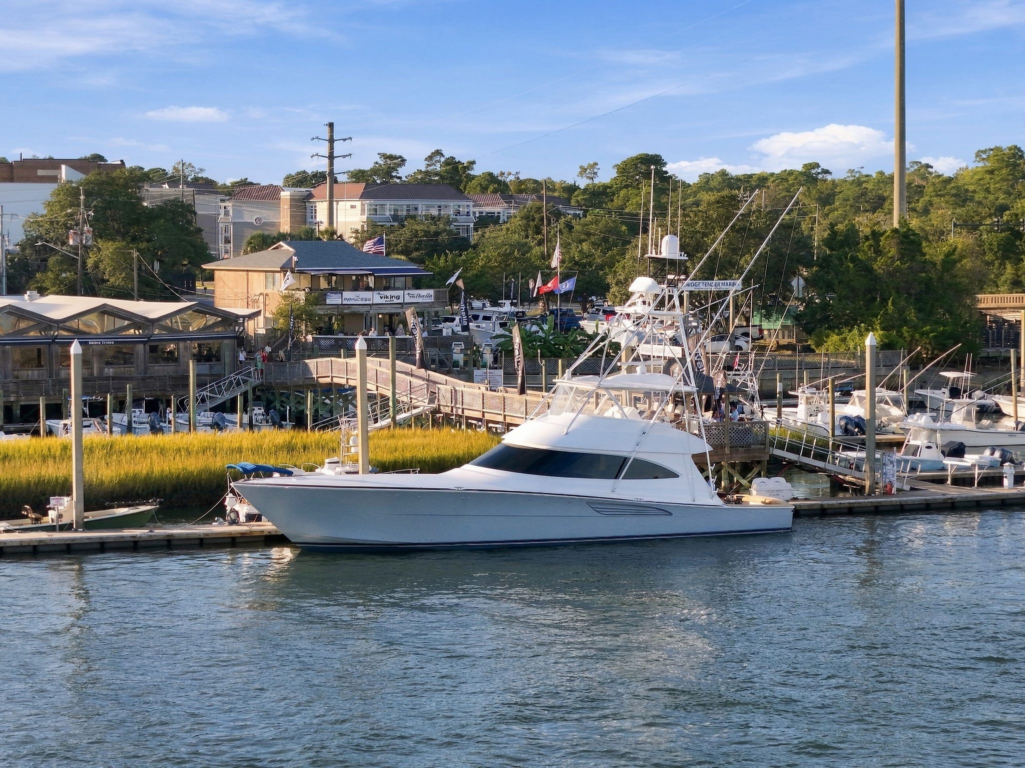 A Viking convertible docked at Bridge Tender Marina on the Intracoastal Waterway in Wrightsville Beach, with the marsh and waterfront buildings behind